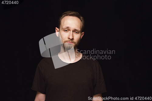 Image of Close up portrait of young man isolated on black studio background