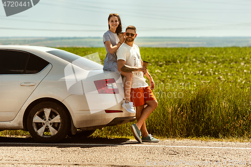 Image of Young couple traveling on the car in sunny day