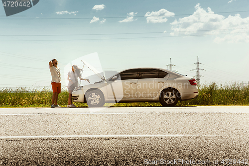 Image of Young couple traveling on the car in sunny day