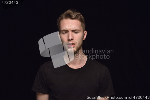 Image of Close up portrait of young man isolated on black studio background