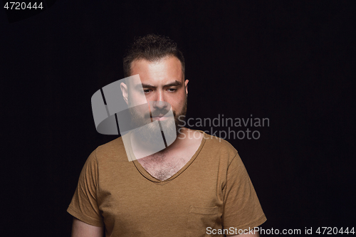 Image of Close up portrait of young man isolated on black studio background