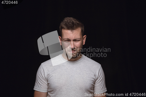 Image of Close up portrait of young man isolated on black studio background