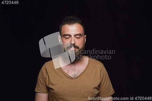 Image of Close up portrait of young man isolated on black studio background