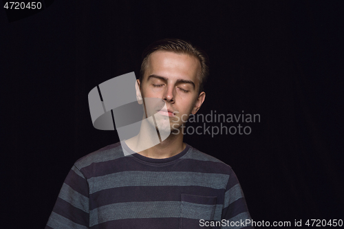 Image of Close up portrait of young man isolated on black studio background