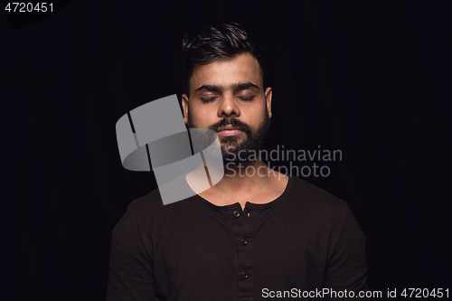 Image of Close up portrait of young man isolated on black studio background