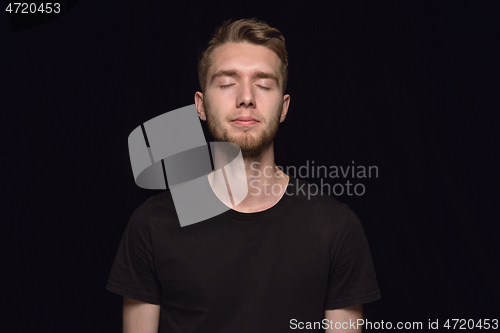 Image of Close up portrait of young man isolated on black studio background