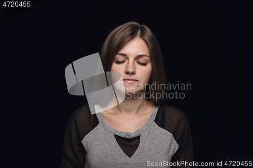 Image of Close up portrait of young woman isolated on black studio background