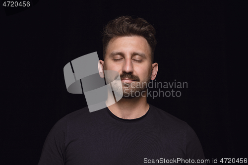 Image of Close up portrait of young man isolated on black studio background