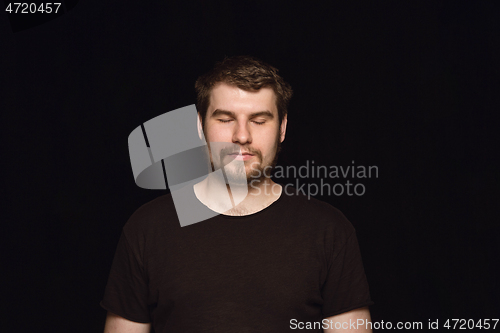 Image of Close up portrait of young man isolated on black studio background