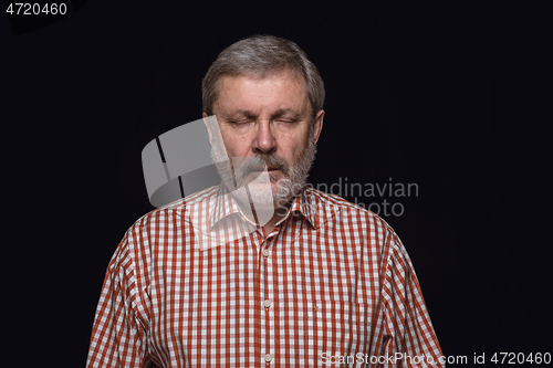 Image of Close up portrait of senior man isolated on black studio background