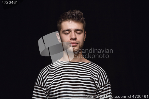 Image of Close up portrait of young man isolated on black studio background