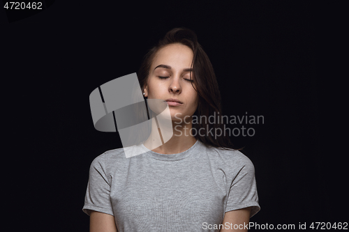 Image of Close up portrait of young woman isolated on black studio background
