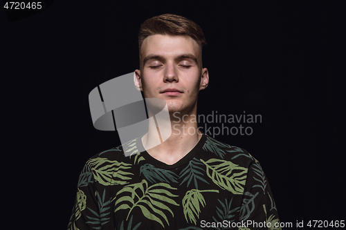 Image of Close up portrait of young man isolated on black studio background