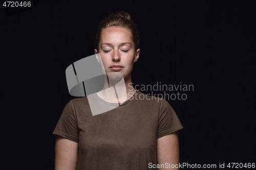 Image of Close up portrait of young woman isolated on black studio background