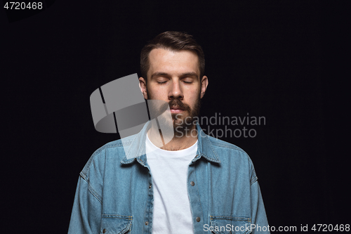 Image of Close up portrait of young man isolated on black studio background