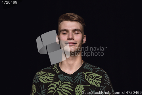 Image of Close up portrait of young man isolated on black studio background