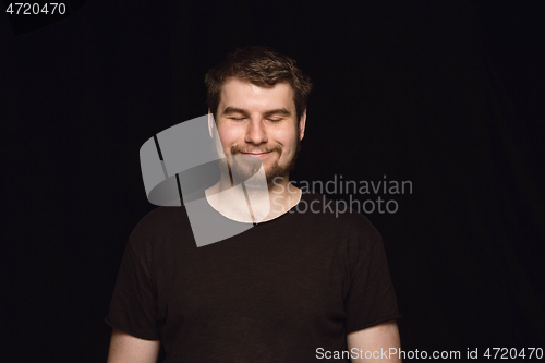 Image of Close up portrait of young man isolated on black studio background