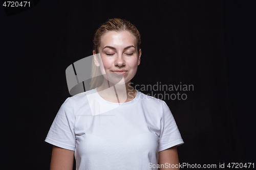 Image of Close up portrait of young woman isolated on black studio background