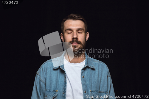 Image of Close up portrait of young man isolated on black studio background