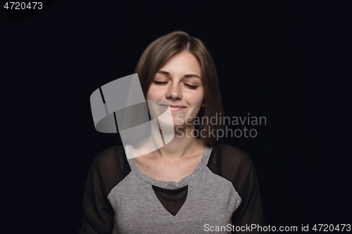 Image of Close up portrait of young woman isolated on black studio background