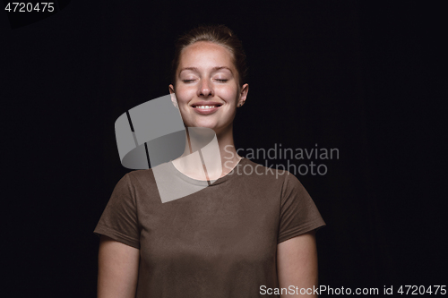 Image of Close up portrait of young woman isolated on black studio background