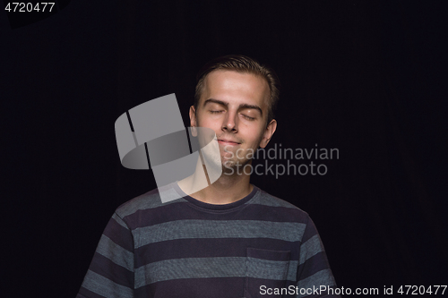 Image of Close up portrait of young man isolated on black studio background