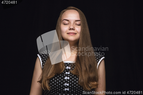 Image of Close up portrait of young woman isolated on black studio background