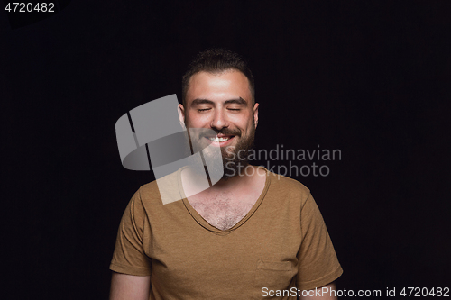 Image of Close up portrait of young man isolated on black studio background