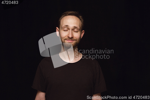 Image of Close up portrait of young man isolated on black studio background