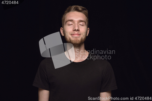 Image of Close up portrait of young man isolated on black studio background