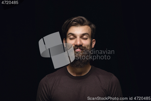 Image of Close up portrait of young man isolated on black studio background