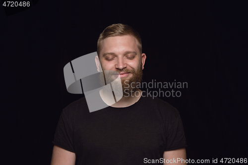 Image of Close up portrait of young man isolated on black studio background