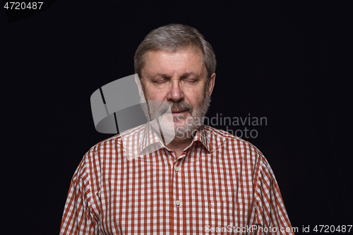 Image of Close up portrait of senior man isolated on black studio background