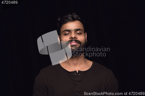 Image of Close up portrait of young man isolated on black studio background