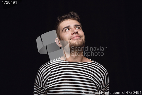 Image of Close up portrait of young man isolated on black studio background