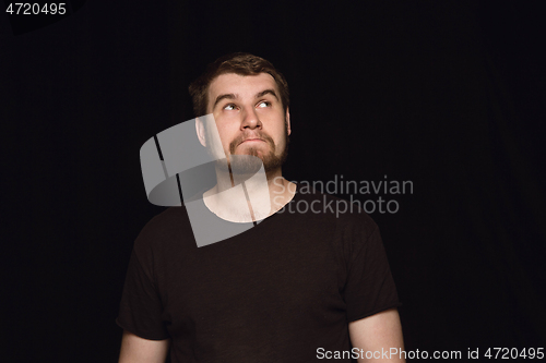 Image of Close up portrait of young man isolated on black studio background