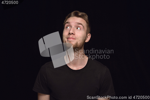 Image of Close up portrait of young man isolated on black studio background