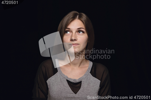 Image of Close up portrait of young woman isolated on black studio background