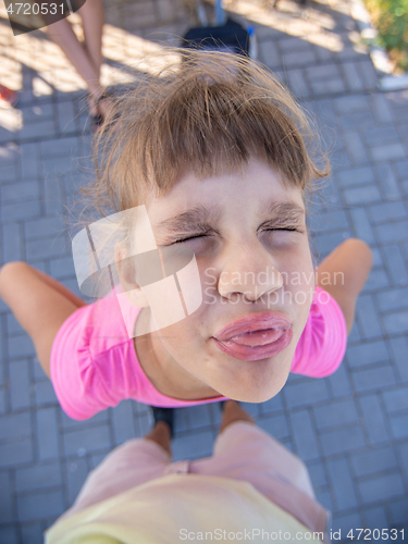 Image of Mischievous girl grimaces and shows a vile muzzle with a tongue