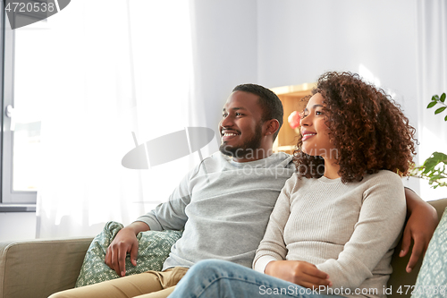 Image of happy african american couple hugging at home