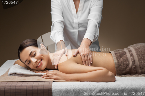 Image of woman lying and having back massage at spa