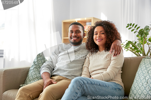 Image of happy african american couple hugging at home