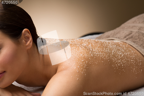 Image of close up of woman with sea salt on skin at spa