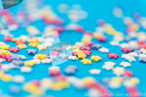 Image of star shaped pastry sprinkles on blue background