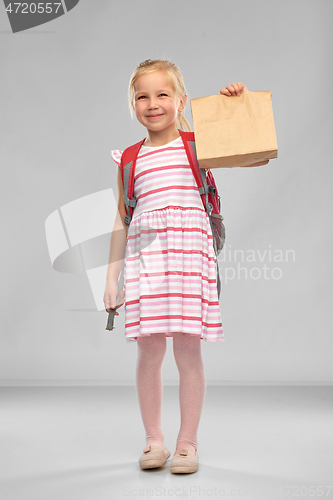 Image of little student girl with school lunch in paper bag