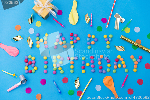 Image of happy birthday of candies and party props on blue