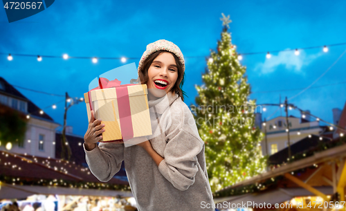 Image of happy woman holding gift box at christmas market