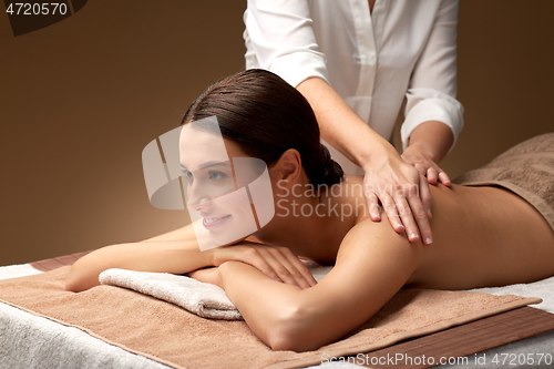 Image of woman lying and having back massage at spa