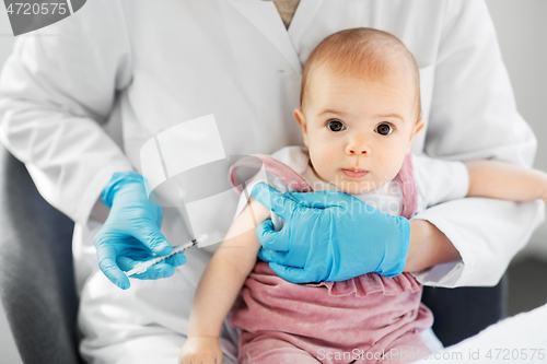 Image of doctor making vaccine for baby patient at clinic