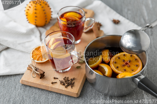 Image of pot with hot mulled wine, orange slices and spices